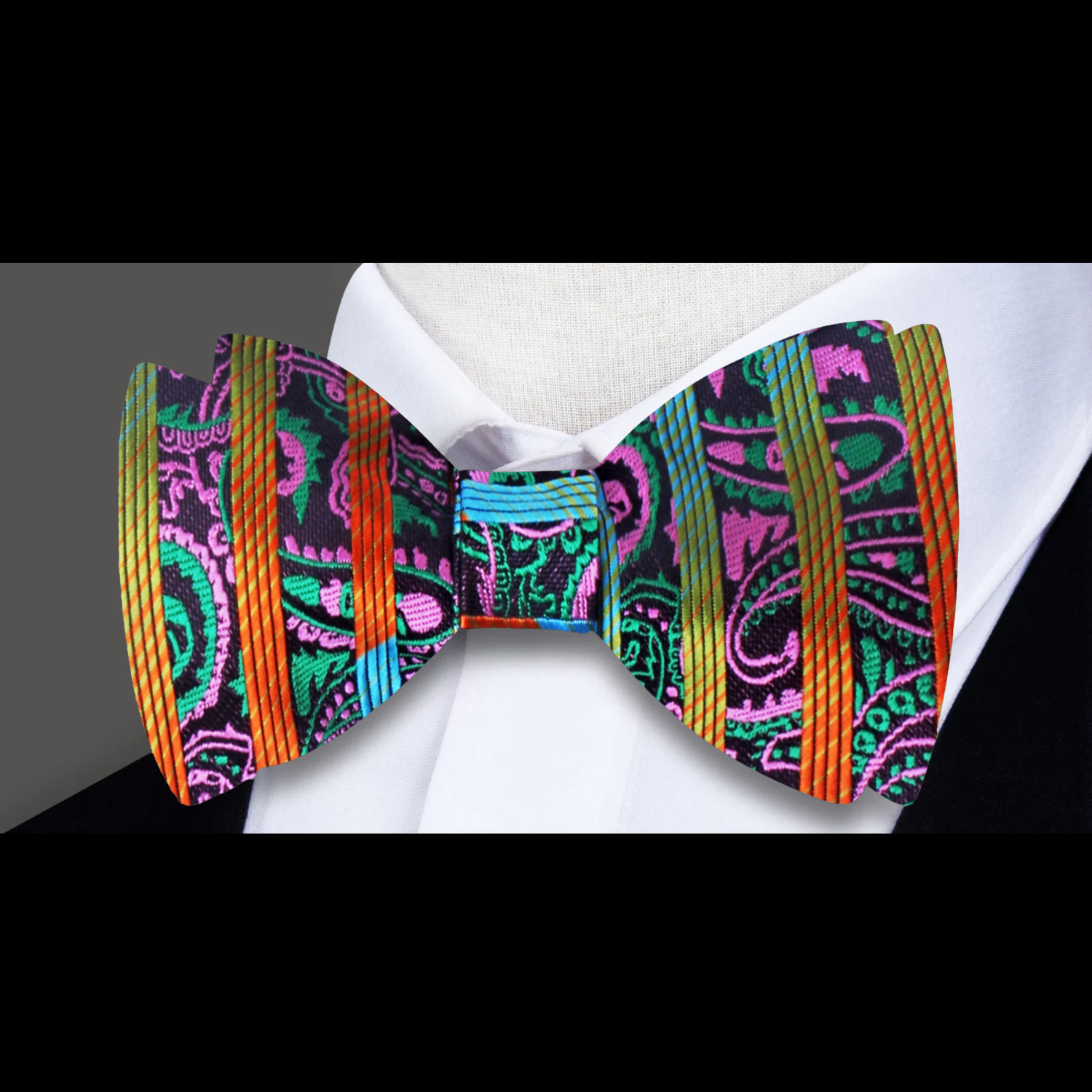 Stylish man wearing a colorful paisley bow tie with a light blue dress shirt