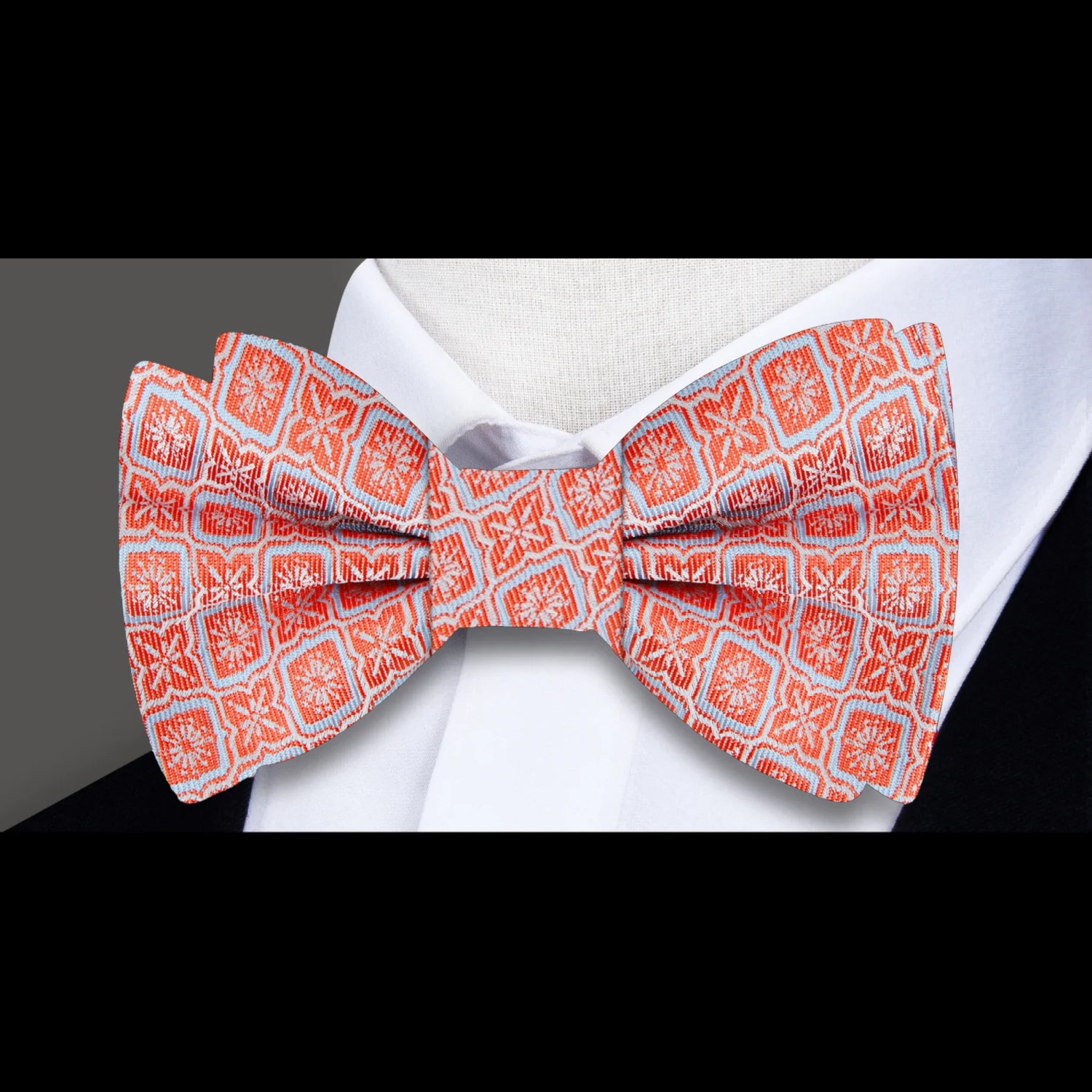 Model wearing the vibrant geometric silk bow tie with a light blue dress shirt at a wedding.