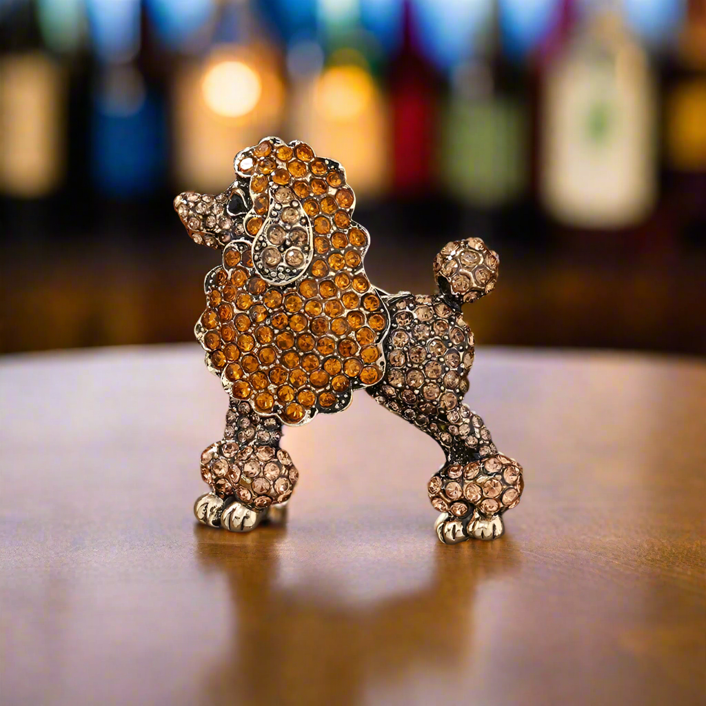 Orange poodle lapel pin displayed on a light blue blazer, highlighting its vibrant color.