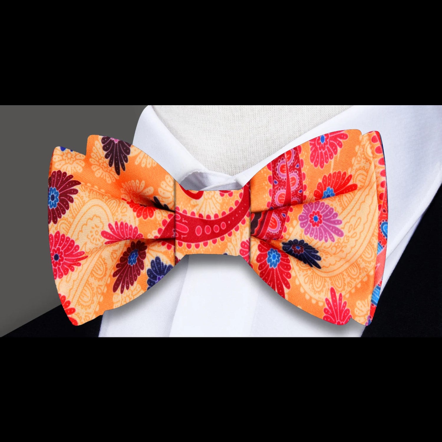 Model wearing the vibrant paisley bow tie paired with a classic white dress shirt, showcasing its elegance.