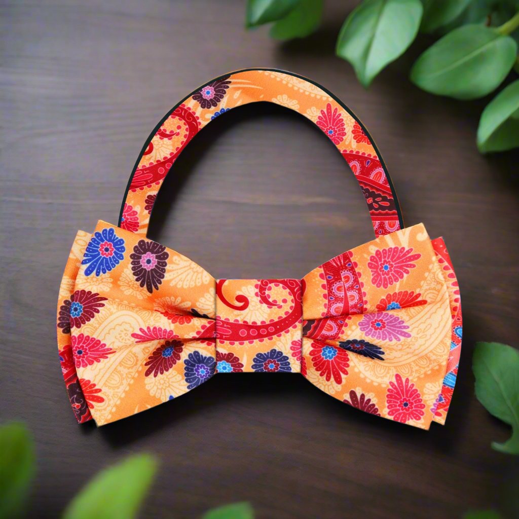 Detail shot of the vibrant paisley bow tie on a navy suit, highlighting the contrast and sophistication.