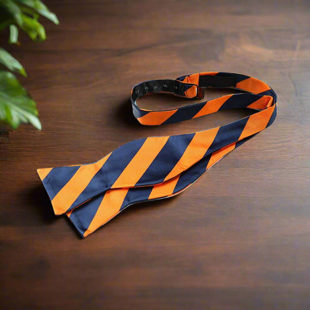 Man wearing a self-tie striped bow tie with a charcoal suit at a formal event