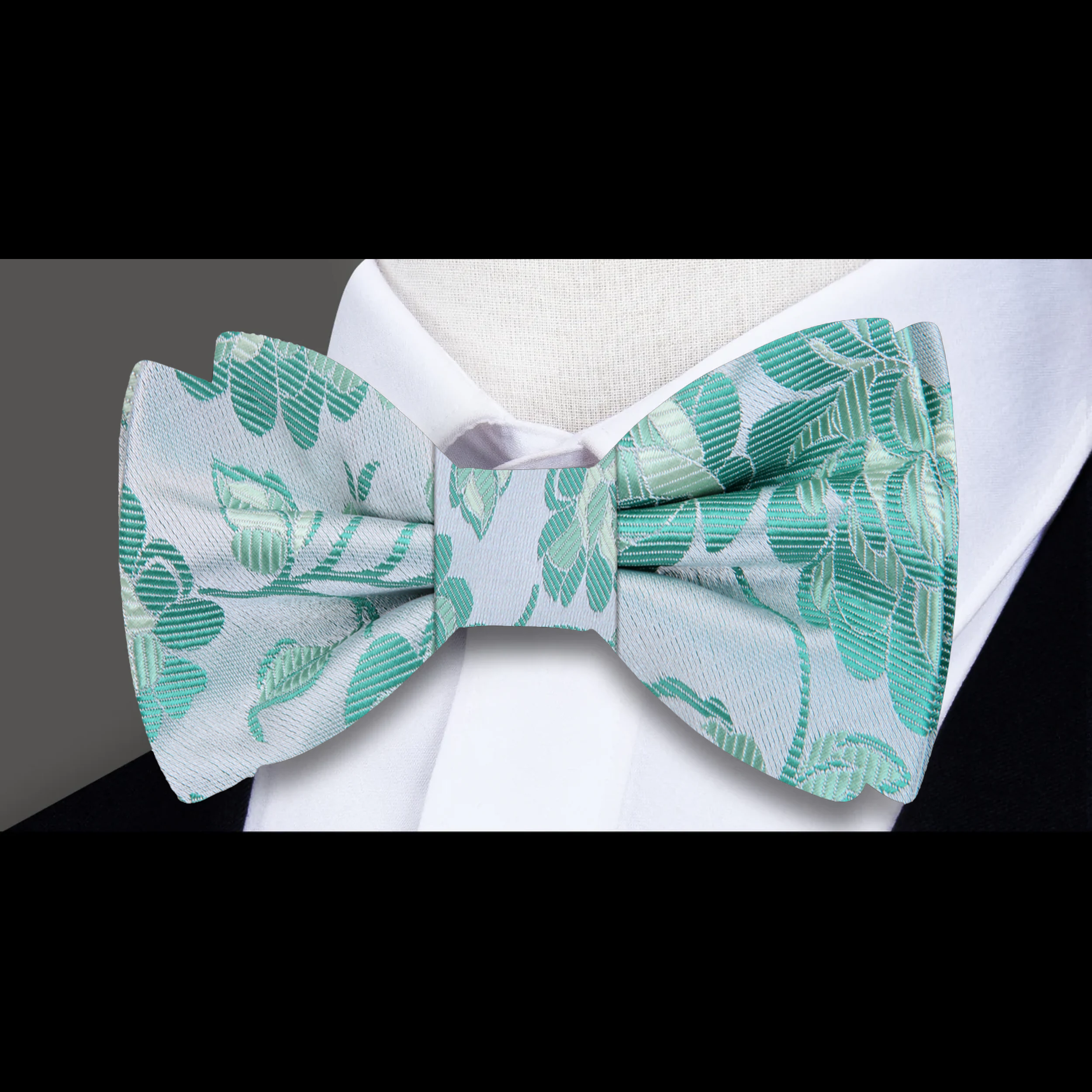 Close-up of the pink floral silk bow tie, highlighting the detailed floral design and luxurious silk fabric.