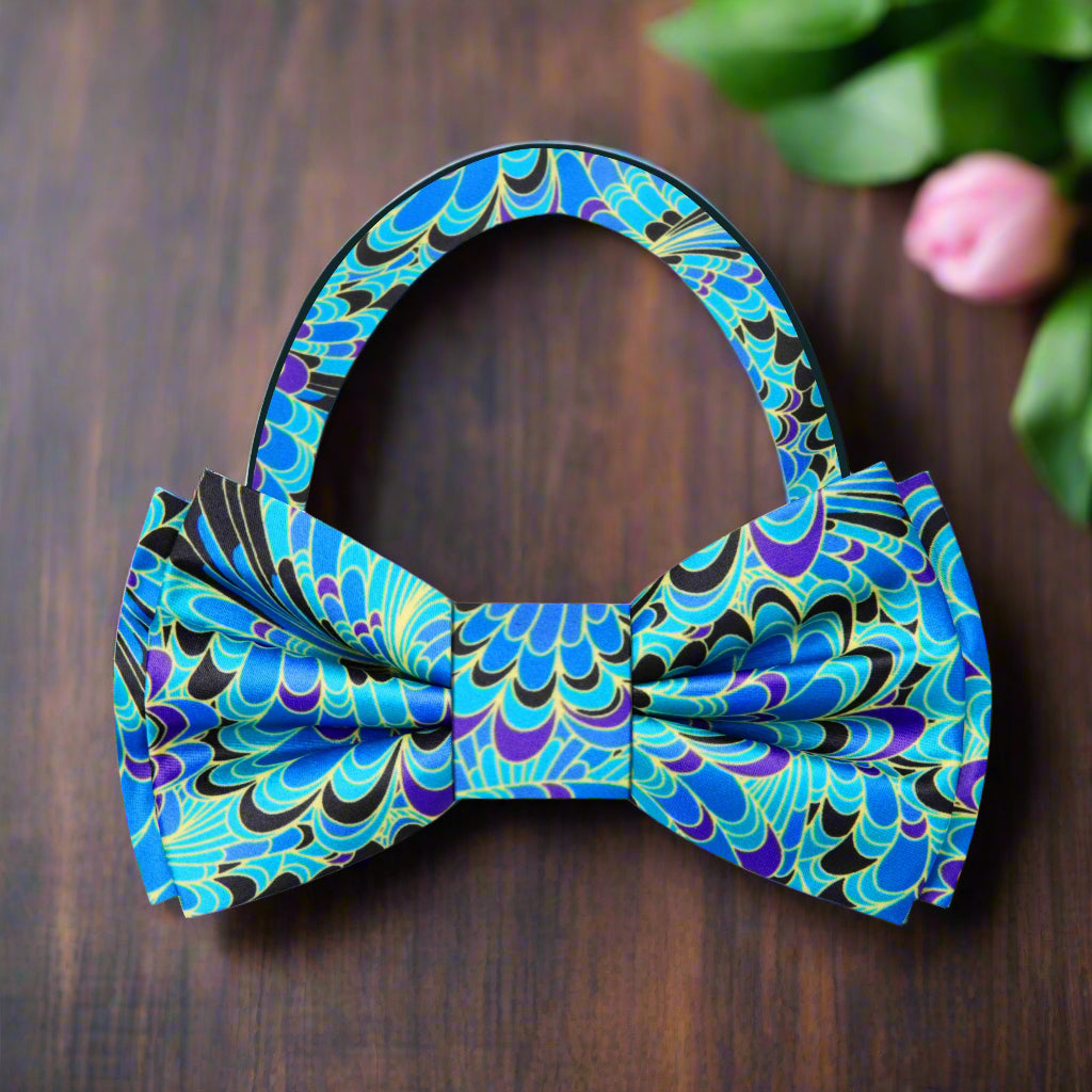 Close-up of the Lintonbury silk bow tie showing detailed peacock feather pattern in vibrant colors