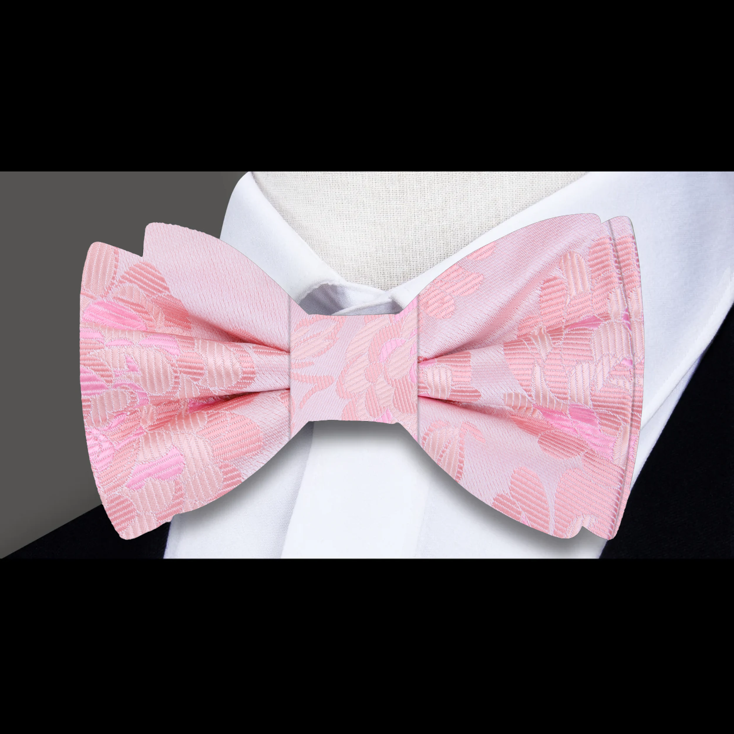 Close-up of the pink floral silk bow tie, highlighting the detailed floral design and luxurious silk fabric.