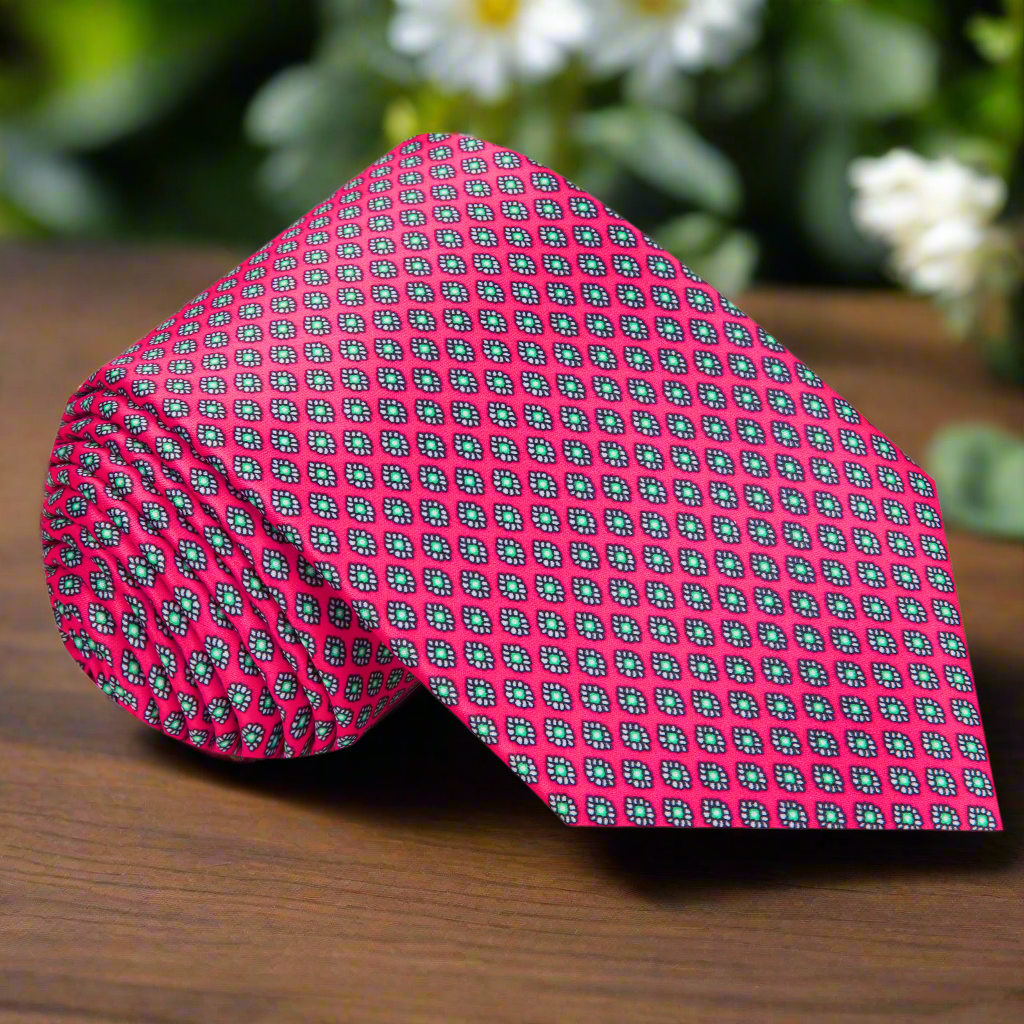 Close-up of watermelon pink silk tie with subtle medallion pattern
