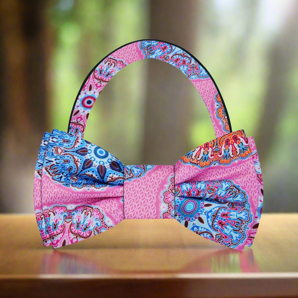 Close-up of vibrant kaleidoscope pattern silk bow tie in pink, ideal for weddings and parties