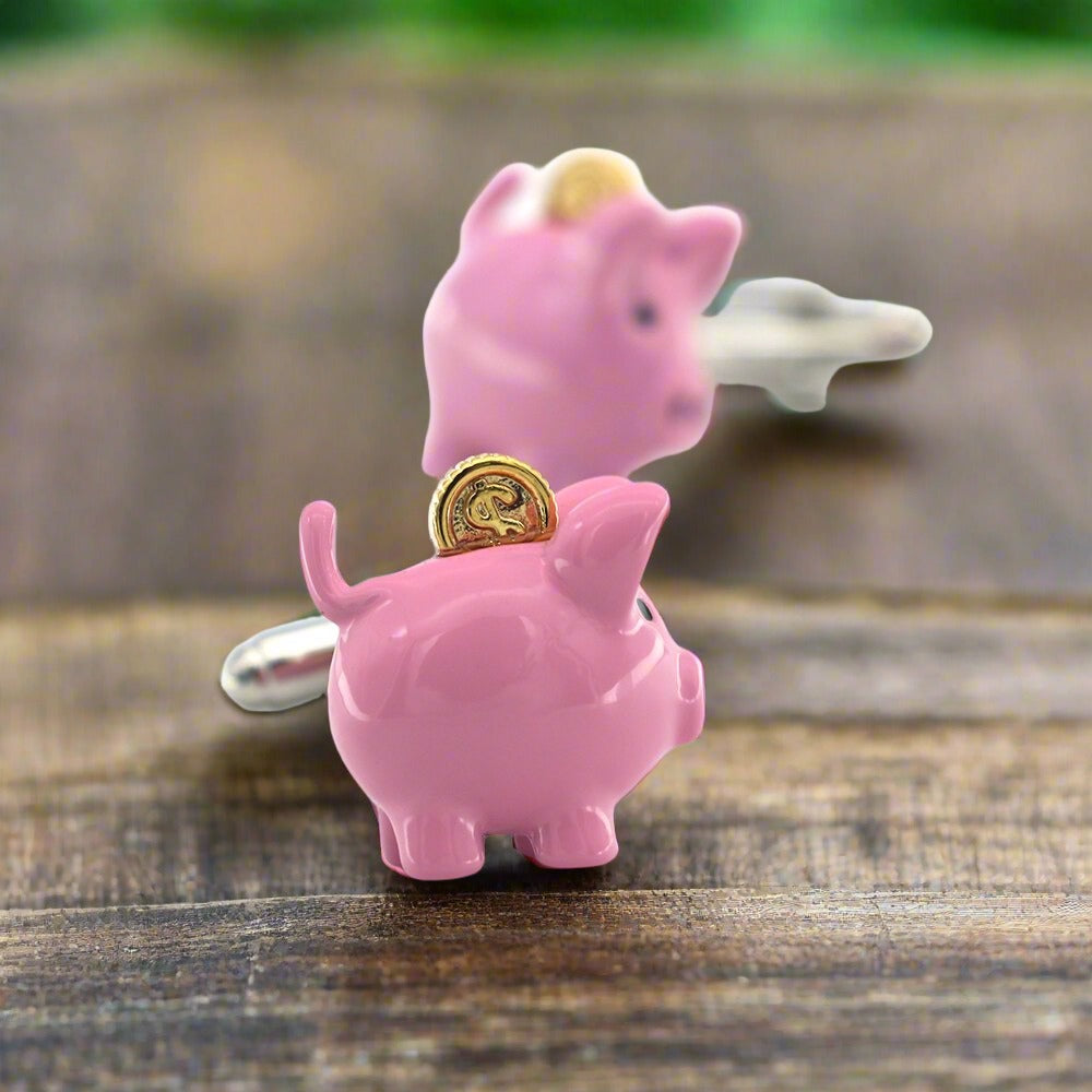 Close-up of whimsical piggy bank cufflink showing chrome body and golden coin accent