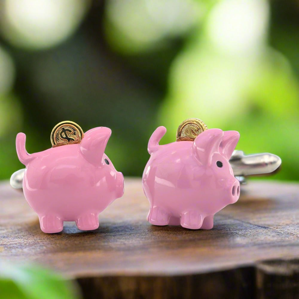 Close-up of whimsical piggy bank cufflink showing chrome body and golden coin accent