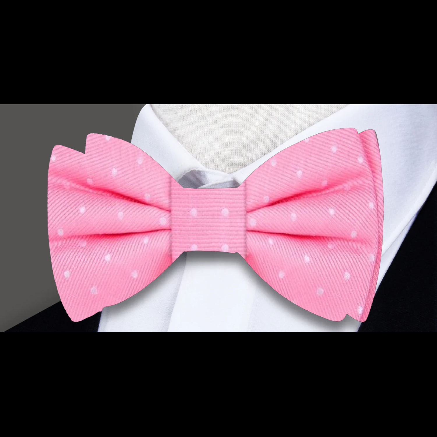 Close-up of navy silk polka dot bow tie with matching pocket square, styled on a white dress shirt