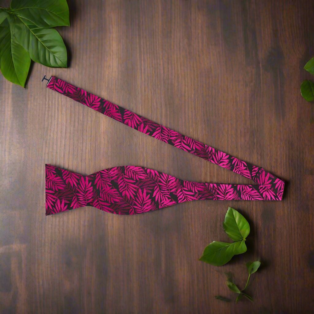 Close-up of black silk bow tie with pink leaves pattern, ideal for formal wear