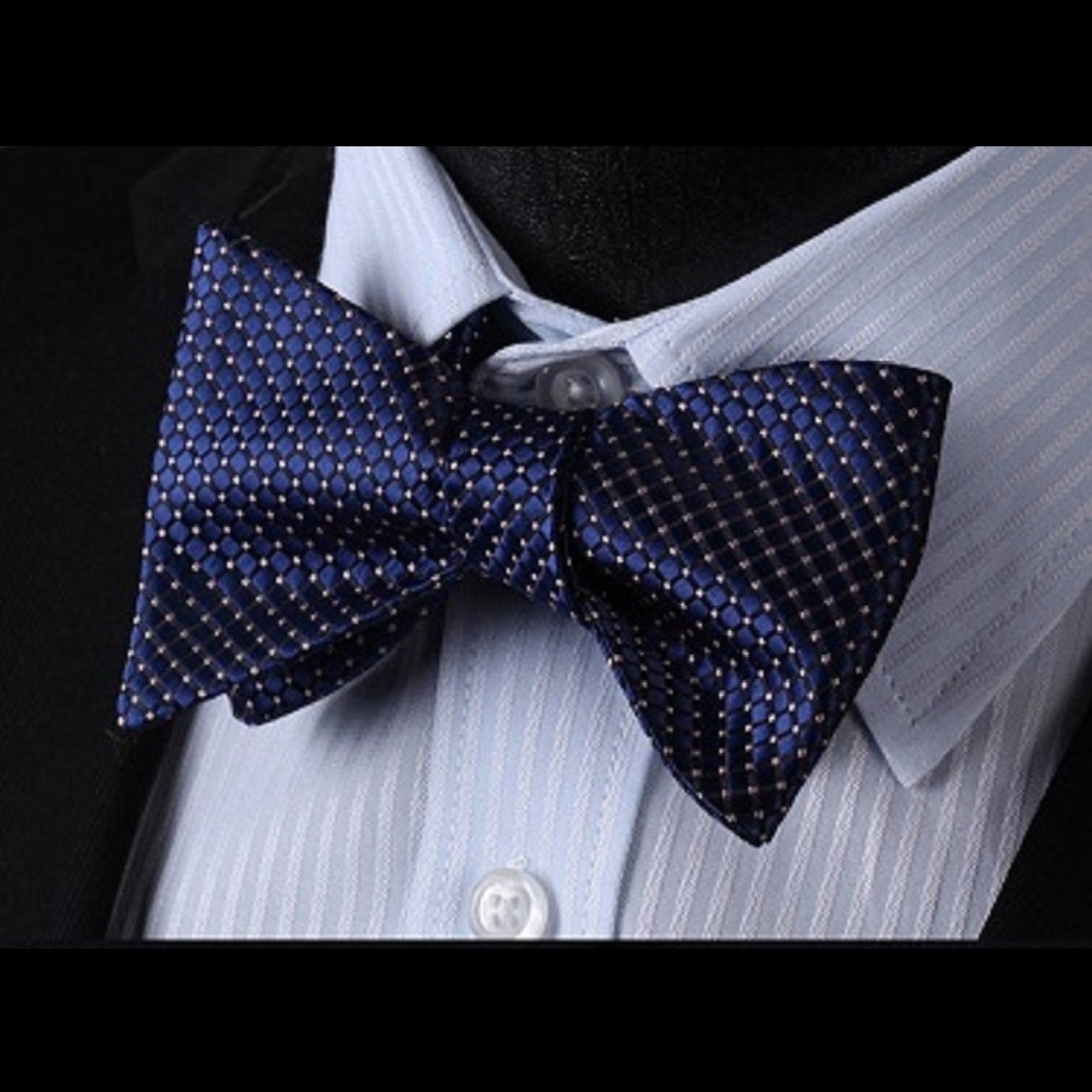 Man adjusting a pre-tied bow tie in a formal setting, showcasing the intricate check pattern