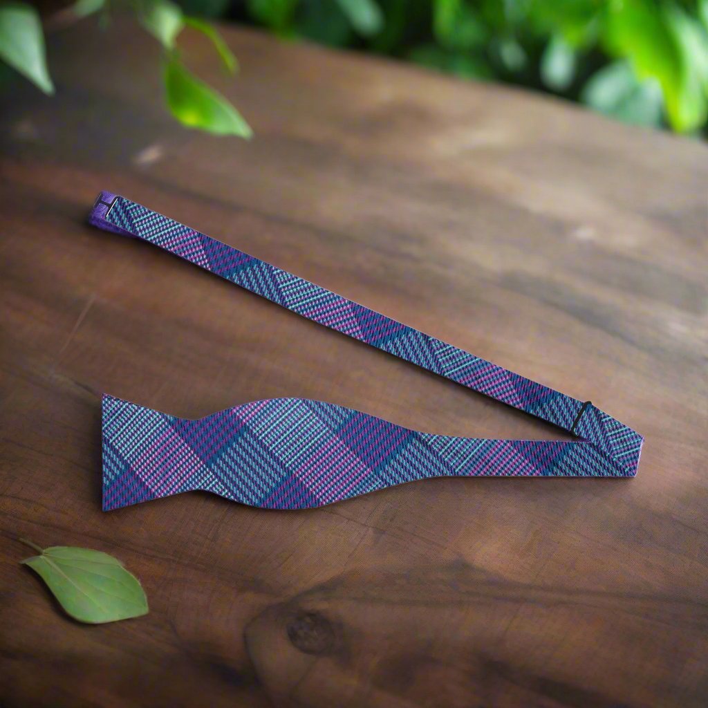 Stylish blue purple plaid bow tie paired with a dark blue suit.