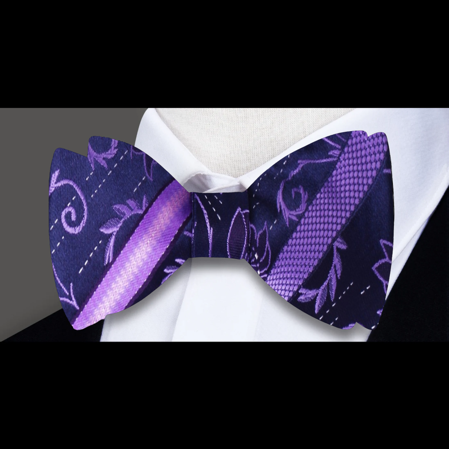 Close-up of black floral bow tie with red accents for formal wear