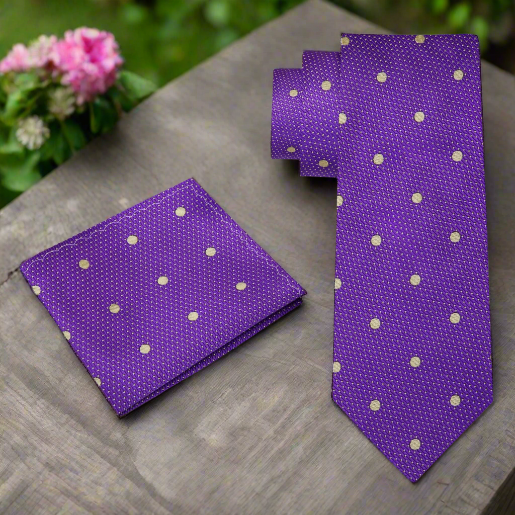 Man wearing a purple polka dot tie with a white dress shirt and navy suit