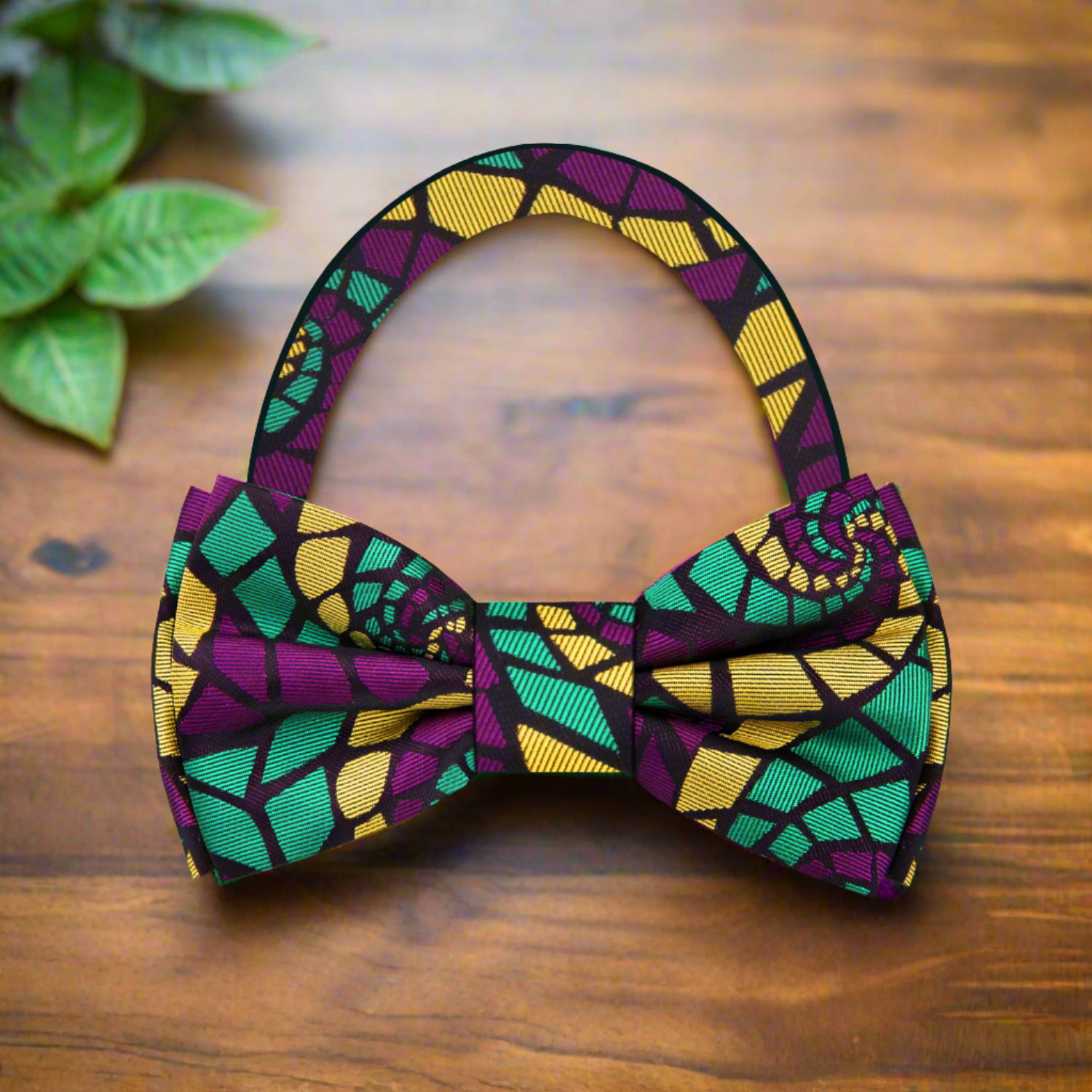 Close-up of vibrant abstract swirl bow tie showcasing purple, green, and yellow colors, ideal for formal wear.