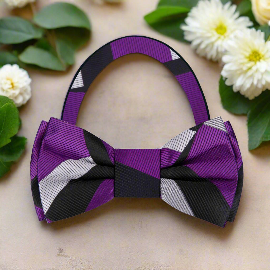 Styled on a pale grey micro-houndstooth shirt with a charcoal suit, showcasing the bow tie’s formal versatility