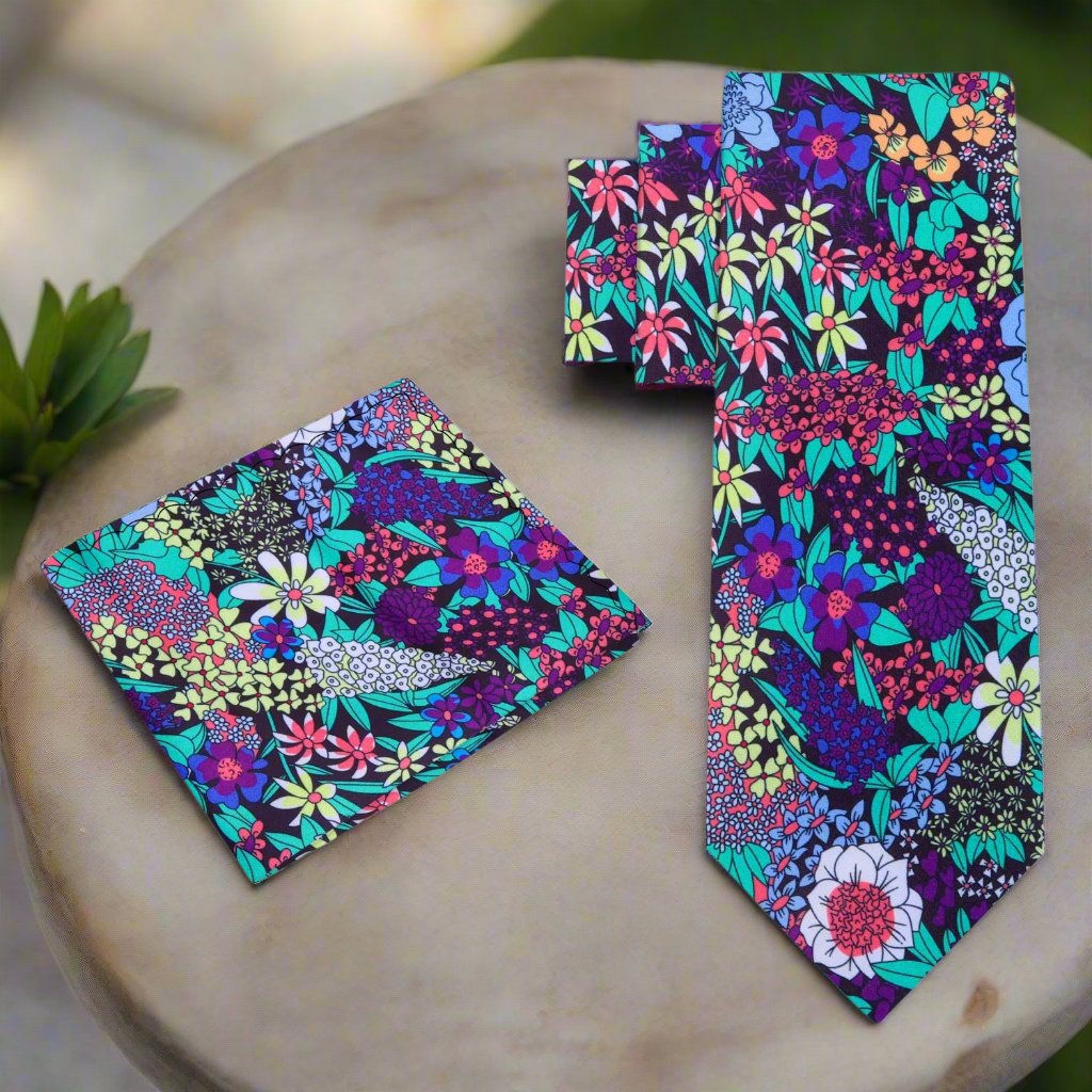 Close-up of vibrant floral silk tie with botanical pattern in green, purple, and pink