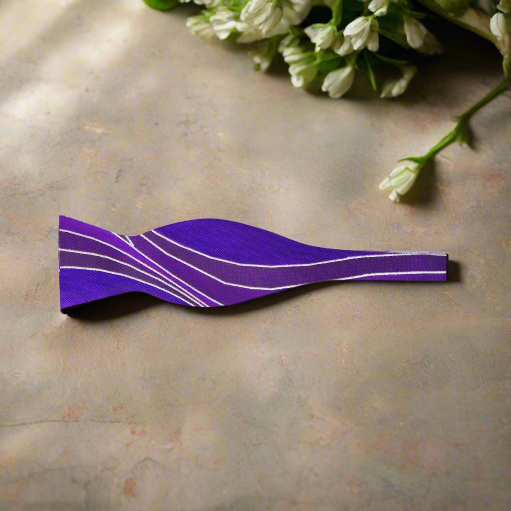 Elegant brown abstract silk bow tie displayed against a white shirt, showcasing its intricate pattern.