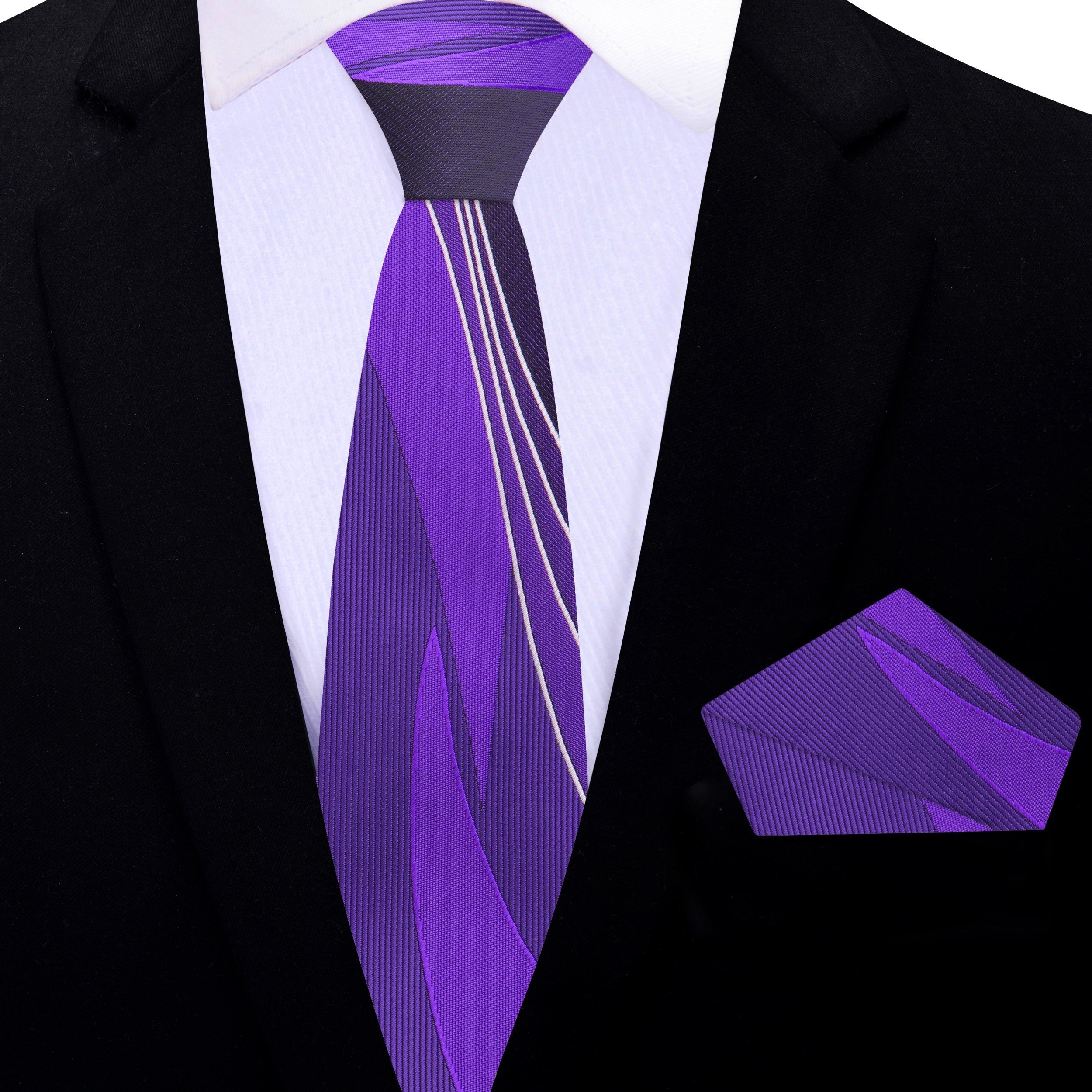 Purple necktie laid alongside a light grey dress shirt and dark grey suit for styling inspiration.