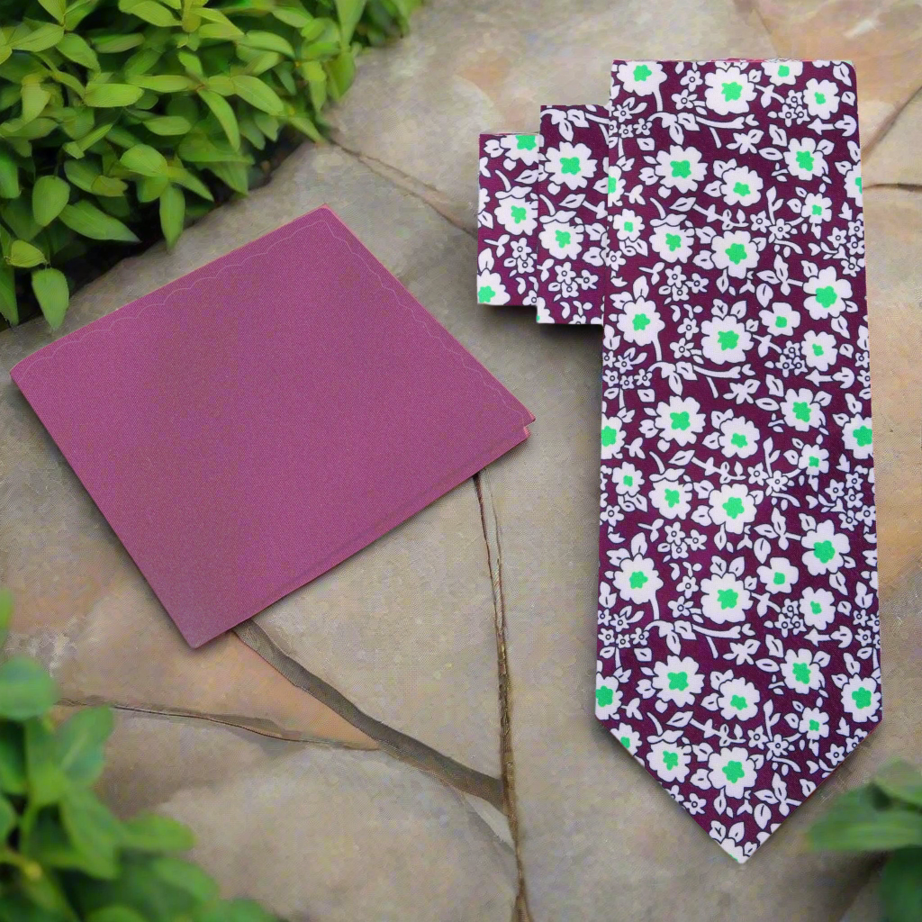 Flat lay of silk necktie and matching pocket square in plum floral design