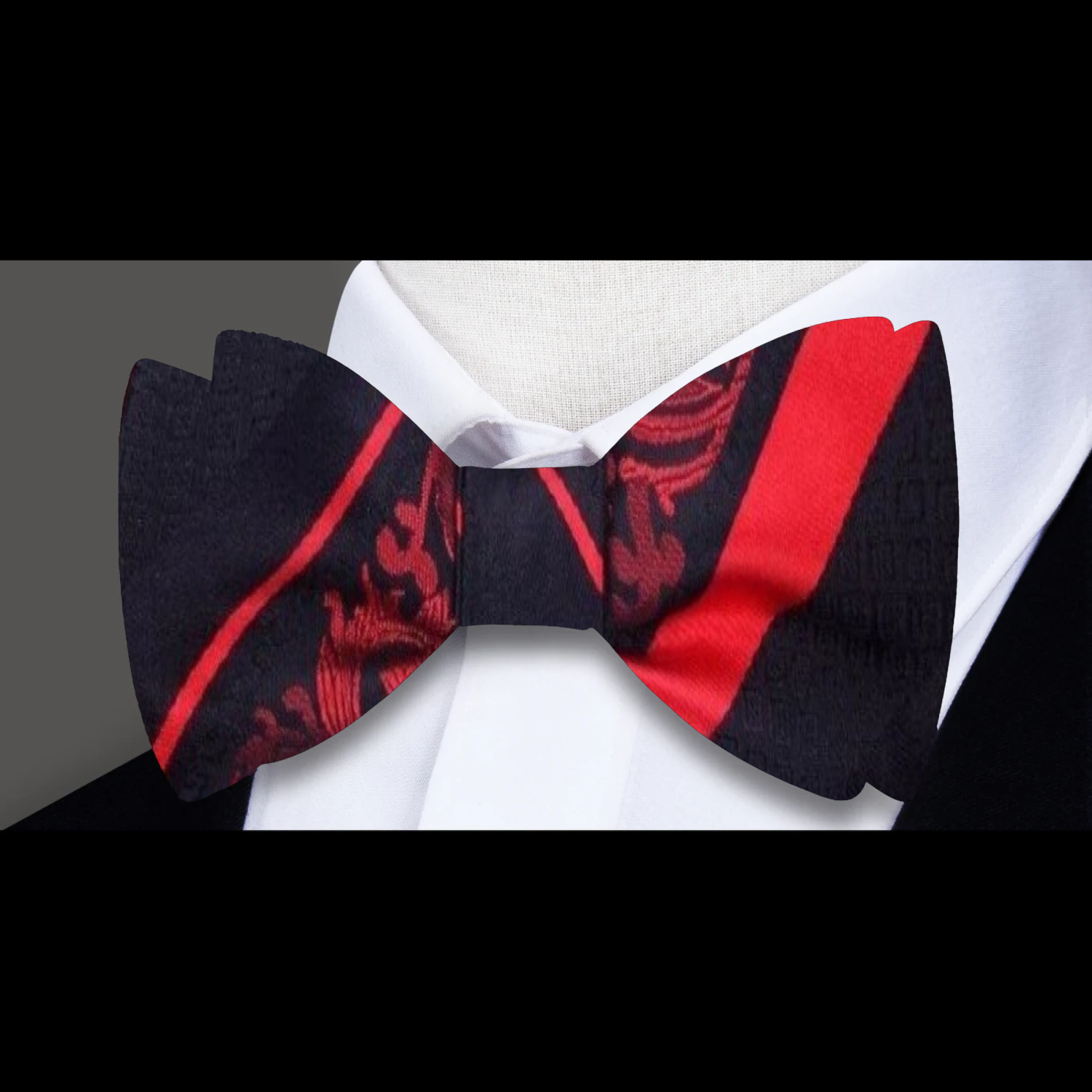 Close-up of black floral bow tie with red accents for formal wear