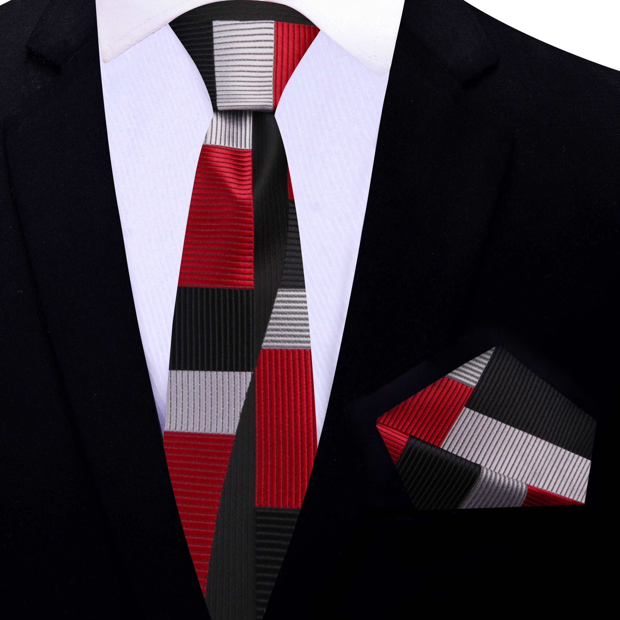 Red geometric mens necktie displayed elegantly against a charcoal grey suit.