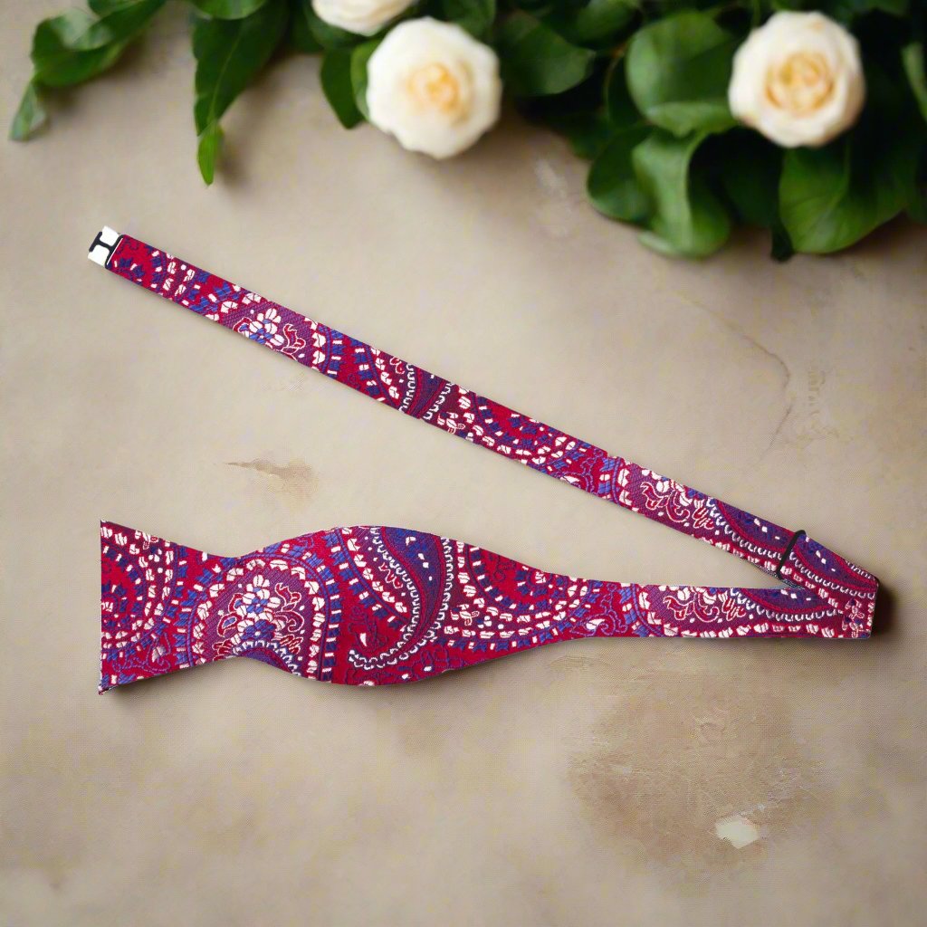 Self-tie red paisley bow tie with a light blue button-down shirt, perfect for semi-formal events.