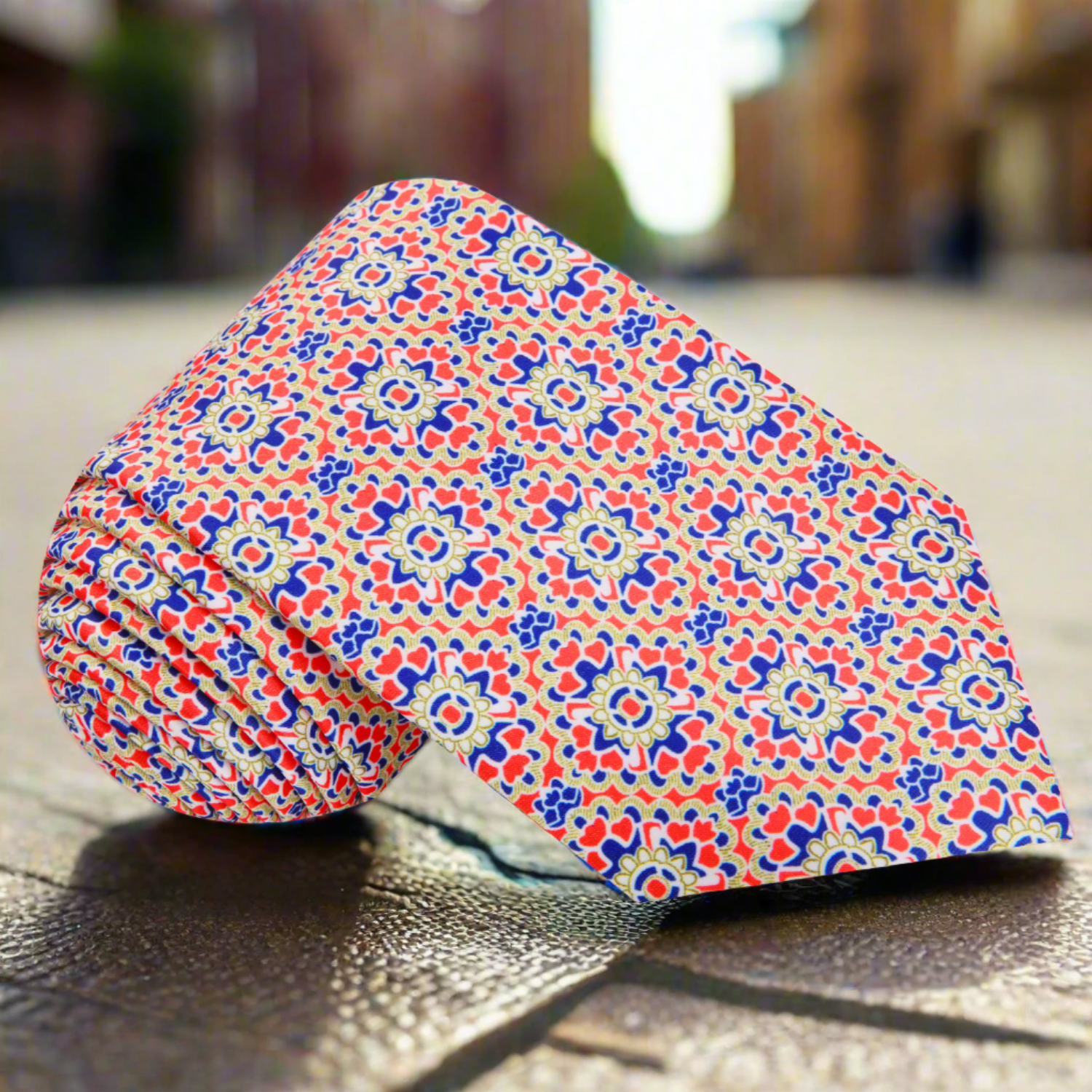 Close-up of the vibrant geometric necktie featuring bold red, navy, and yellow colors.