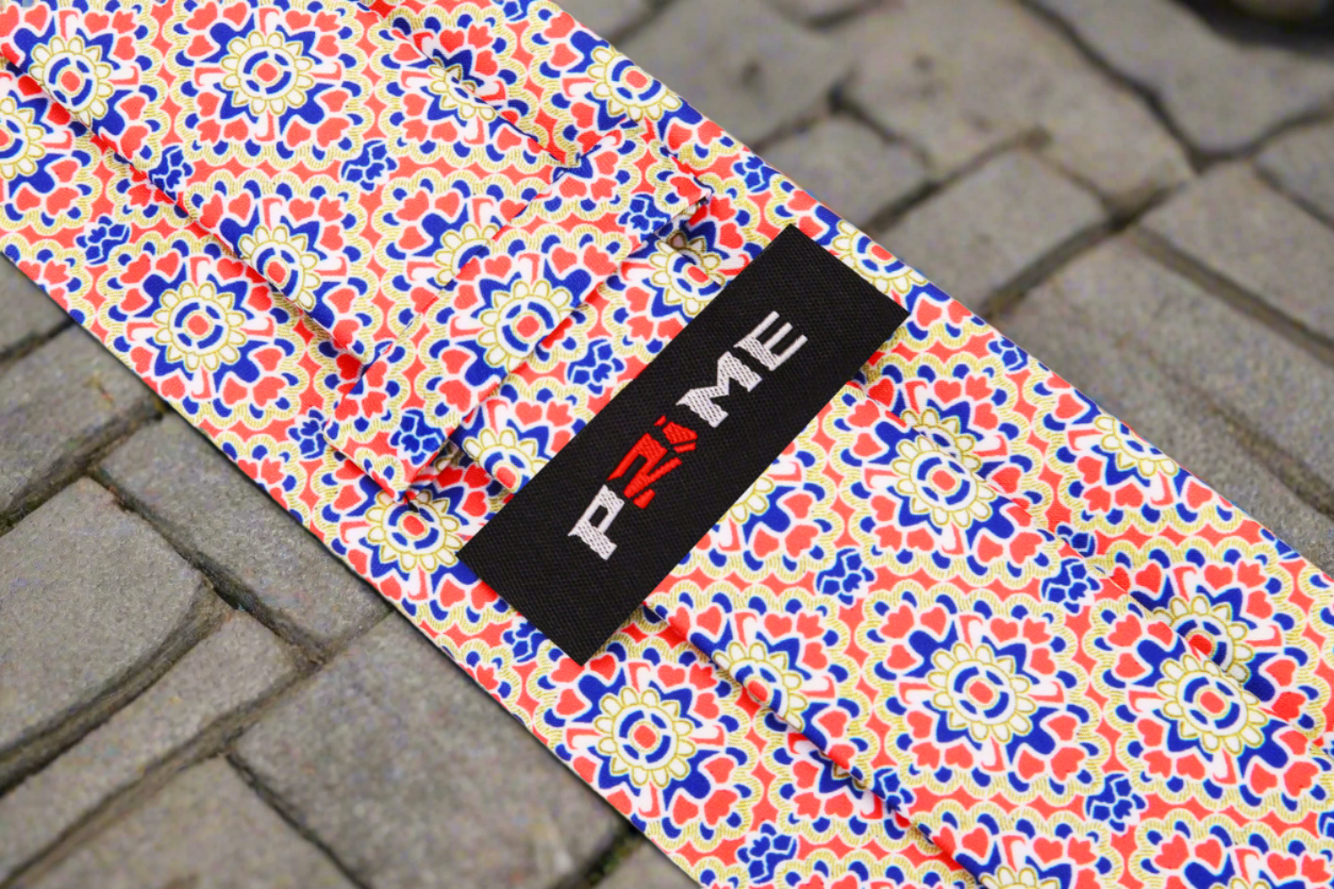 Close-up of the vibrant geometric necktie featuring bold red, navy, and yellow colors.
