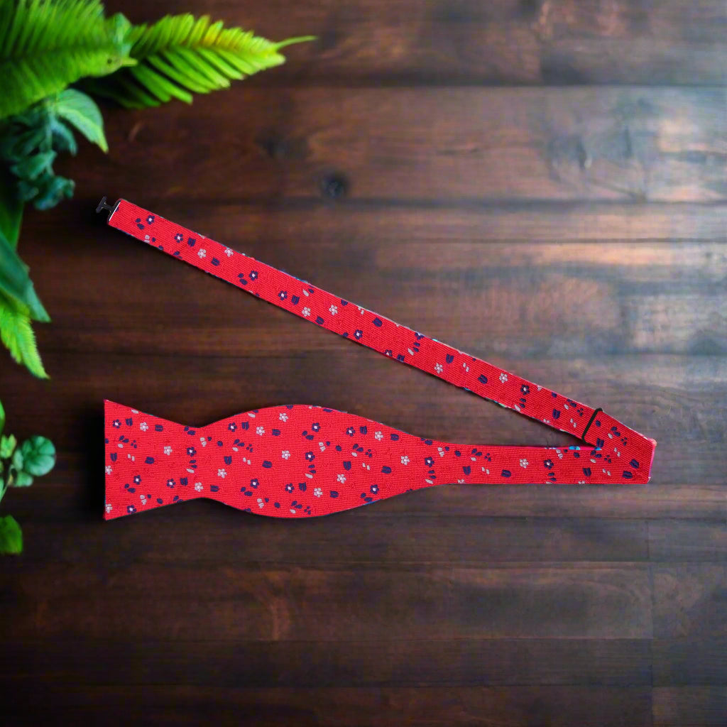 Close-up of the silk fabric and intricate flower pattern on the red bow tie