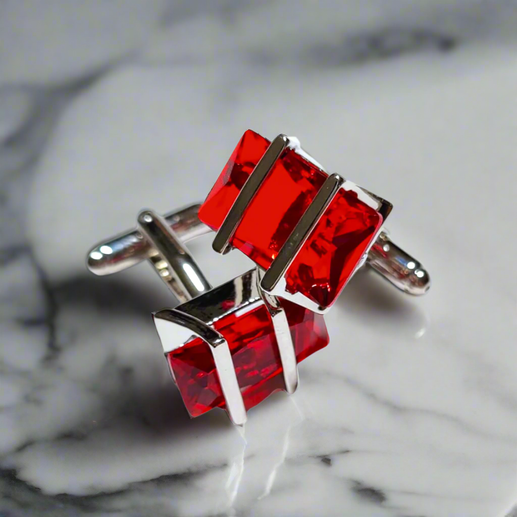 Flat lay of chrome greenstone cufflinks surrounded by a tailored suit, perfect for formal occasions.