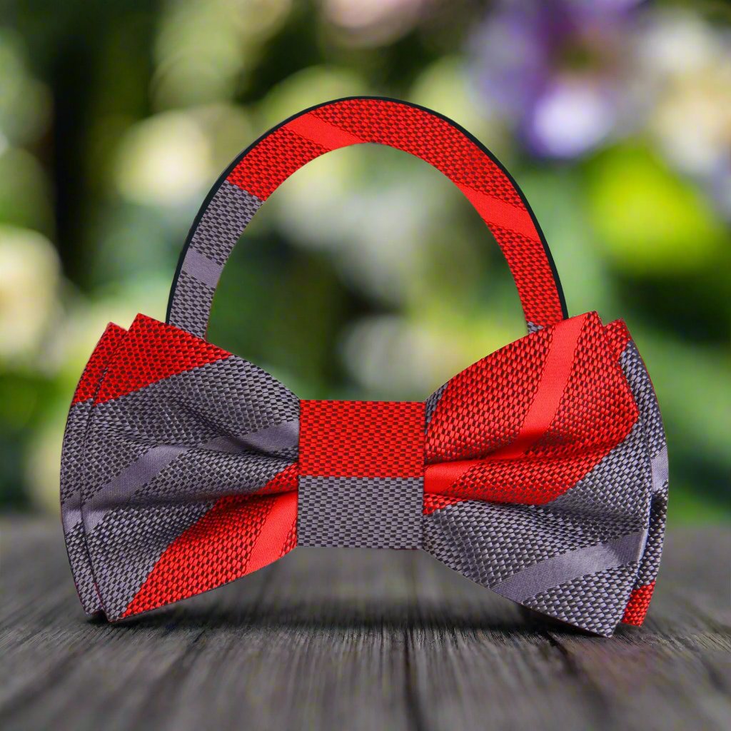 Close-up of the fabric pattern on the mens silk bow tie showing vibrant pink and grey stripes