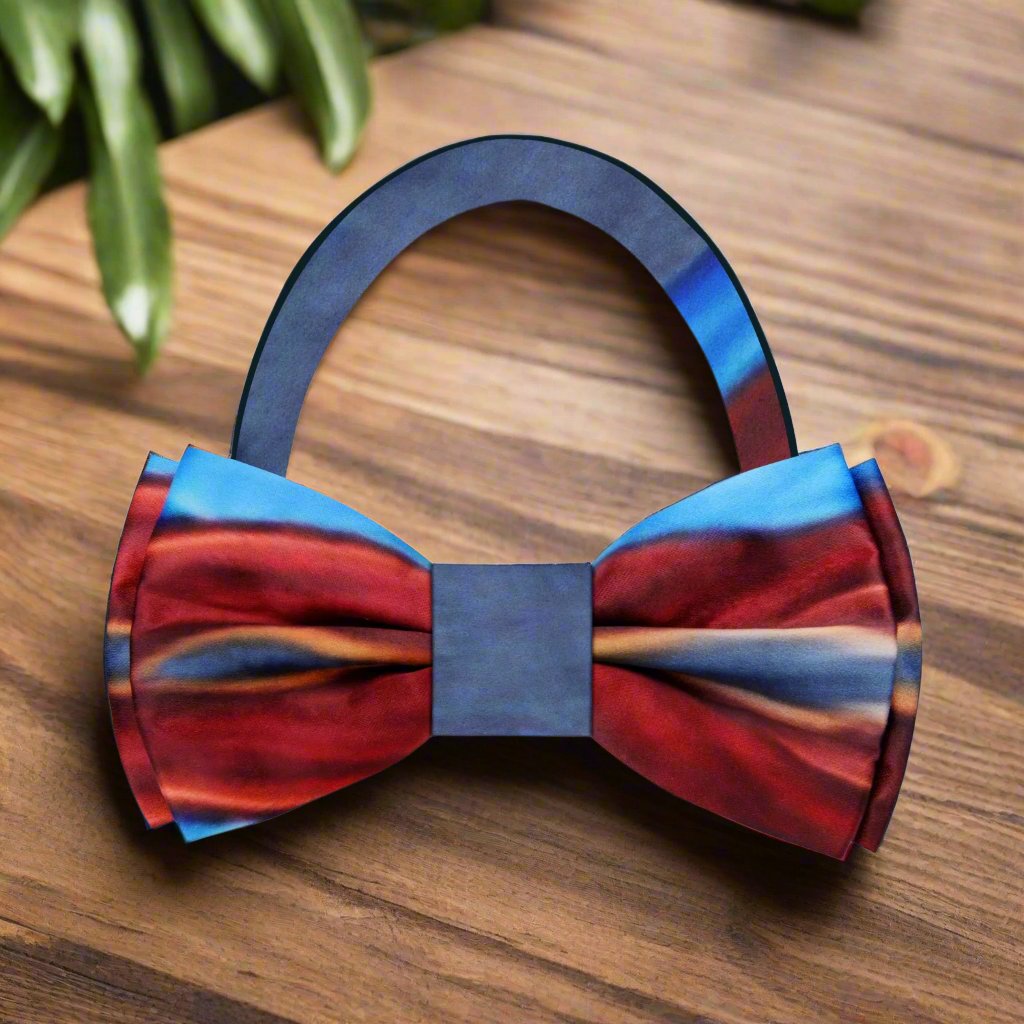 Close-up of the bow ties intricate abstract pattern in shades of red and blue, highlighting its luxurious fabric.