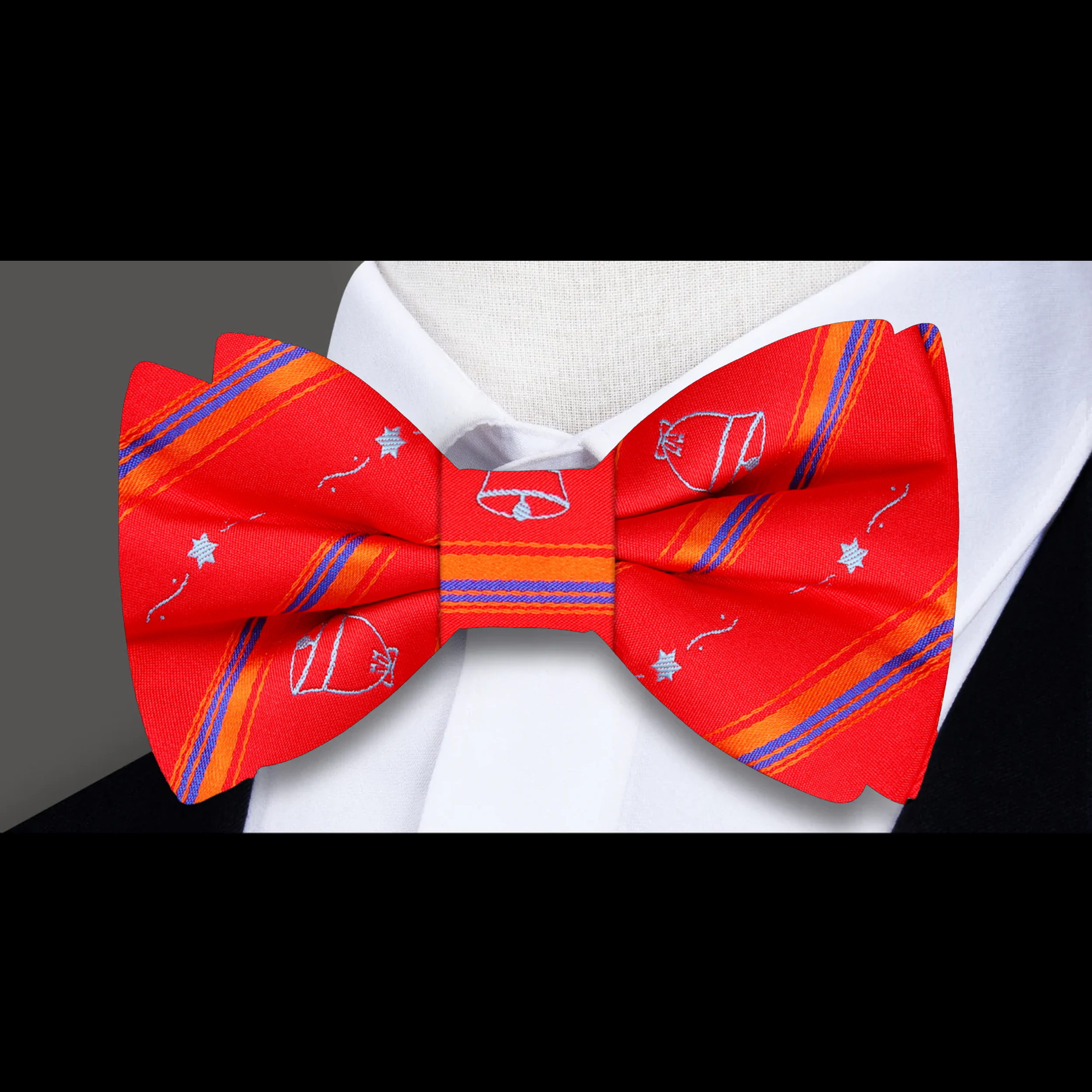 Close-up of Christmas bells and tree bow tie in vibrant red and silver colors