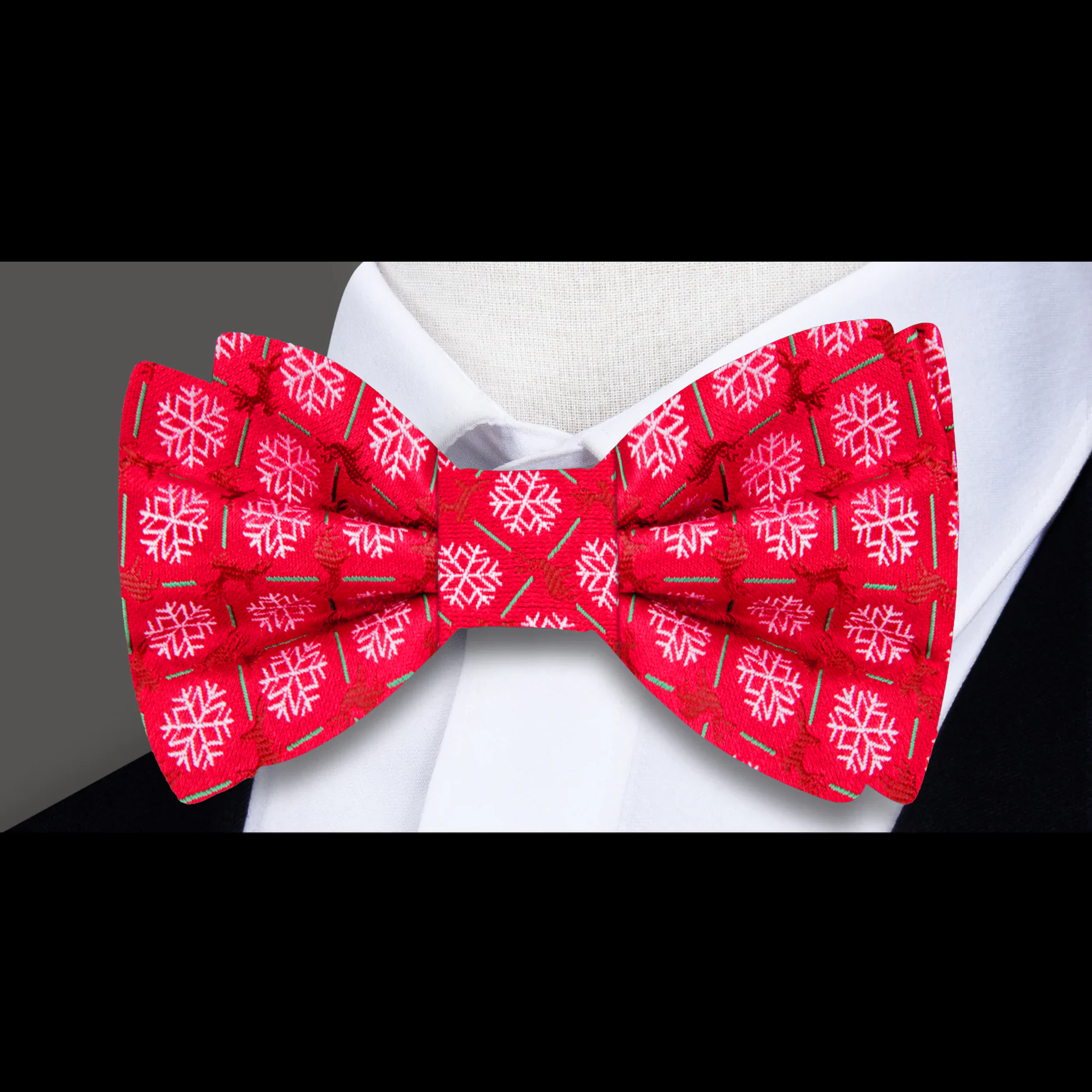 Close-up of a red bow tie with white snowflakes and brown reindeers for holiday celebrations