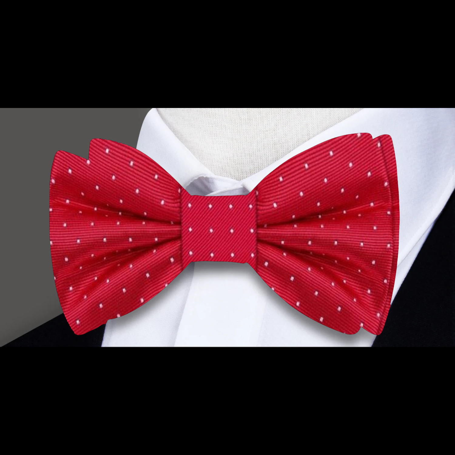 White polka dot silk bow tie and pocket square laid flat to show texture and craftsmanship