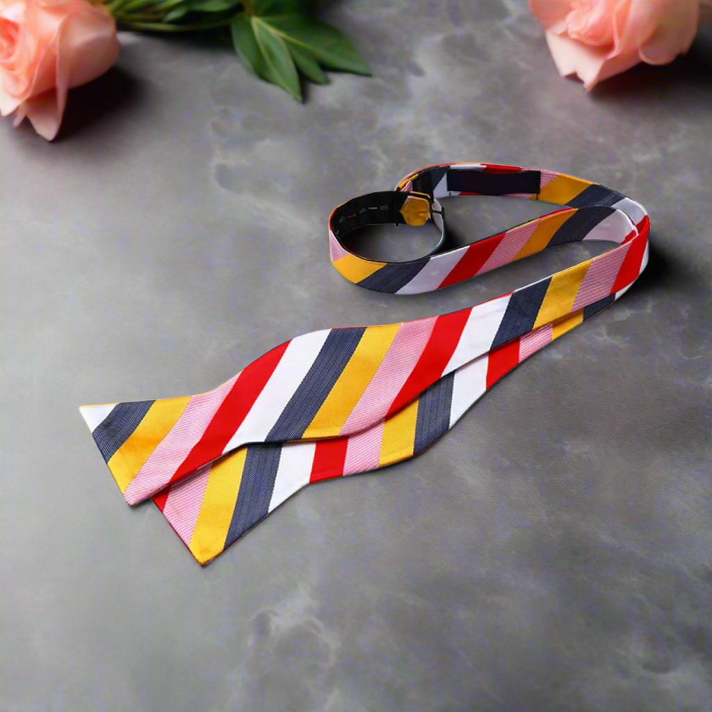 Elegant man at a gallery opening wearing a navy and white stripe bow tie, adding personality to his outfit.