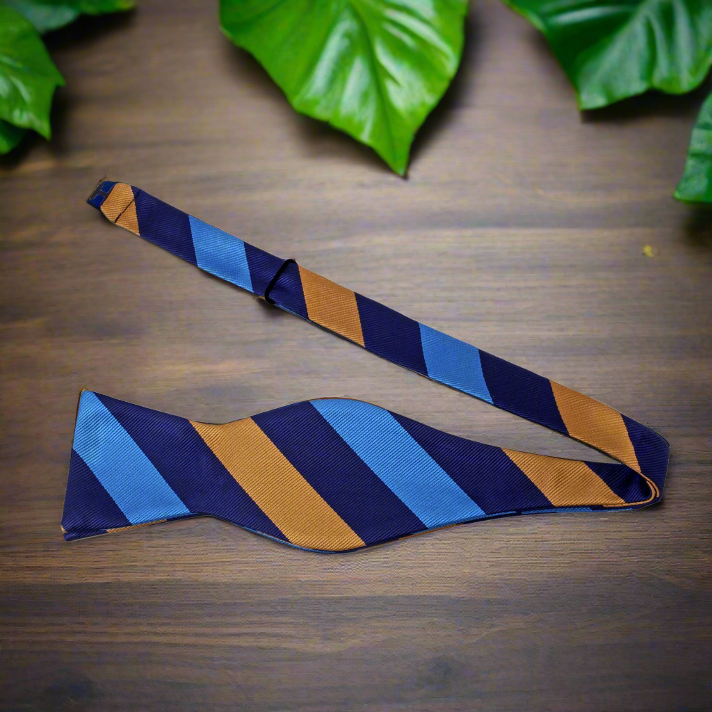 Man wearing a self-tie striped bow tie with a charcoal suit at a formal event