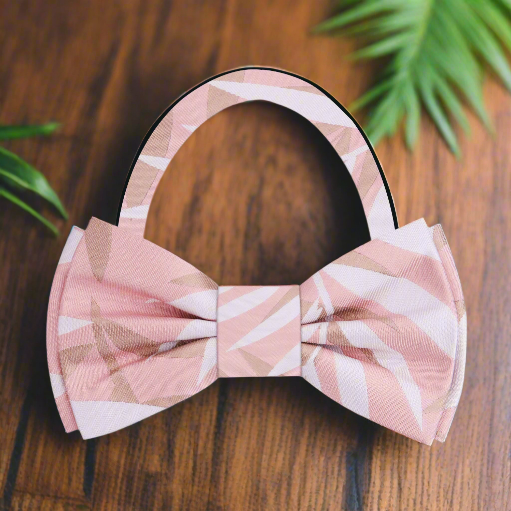 Close-up of the light pink bow tie showcasing its silky texture and intricate sketch pattern.