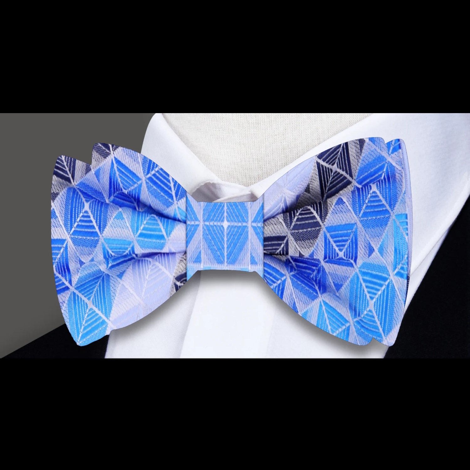 Close-up of the blue geometric bow tie, highlighting the intricate design and silk texture.