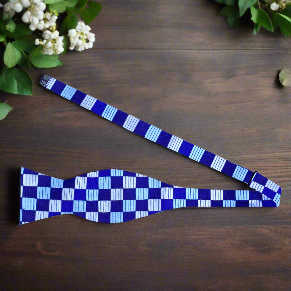 Man adjusting a dark blue silk bow tie for a formal event