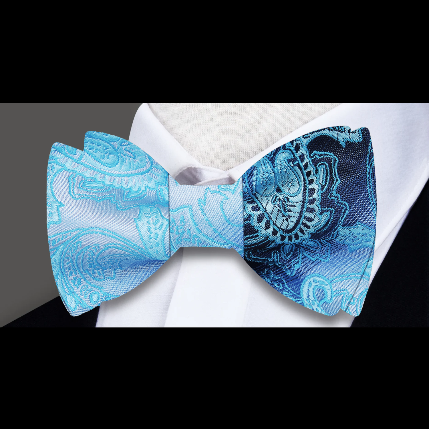 Showcase of the blue paisley bow tie paired with a charcoal suit at a business reception.