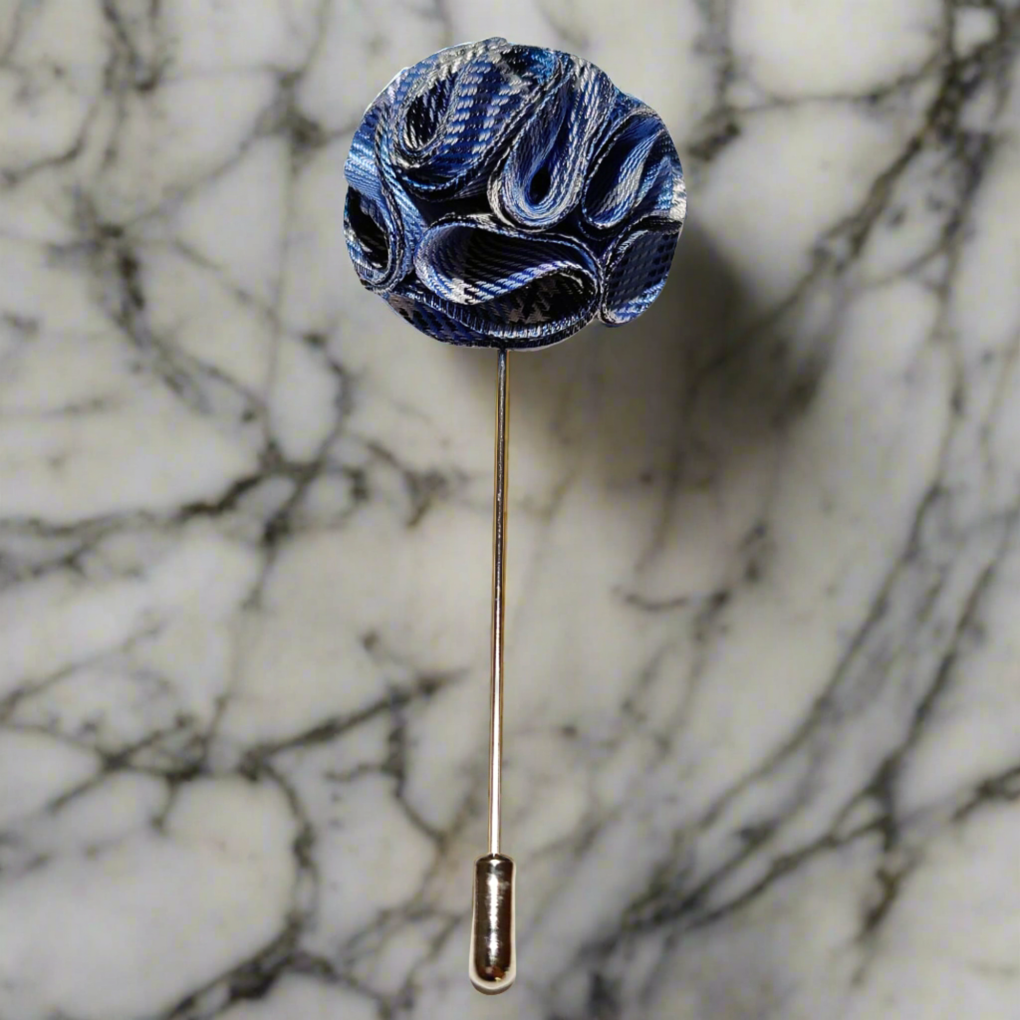 Fabric flower lapel pin on a dark suit, showing detailed petals and secure fastening