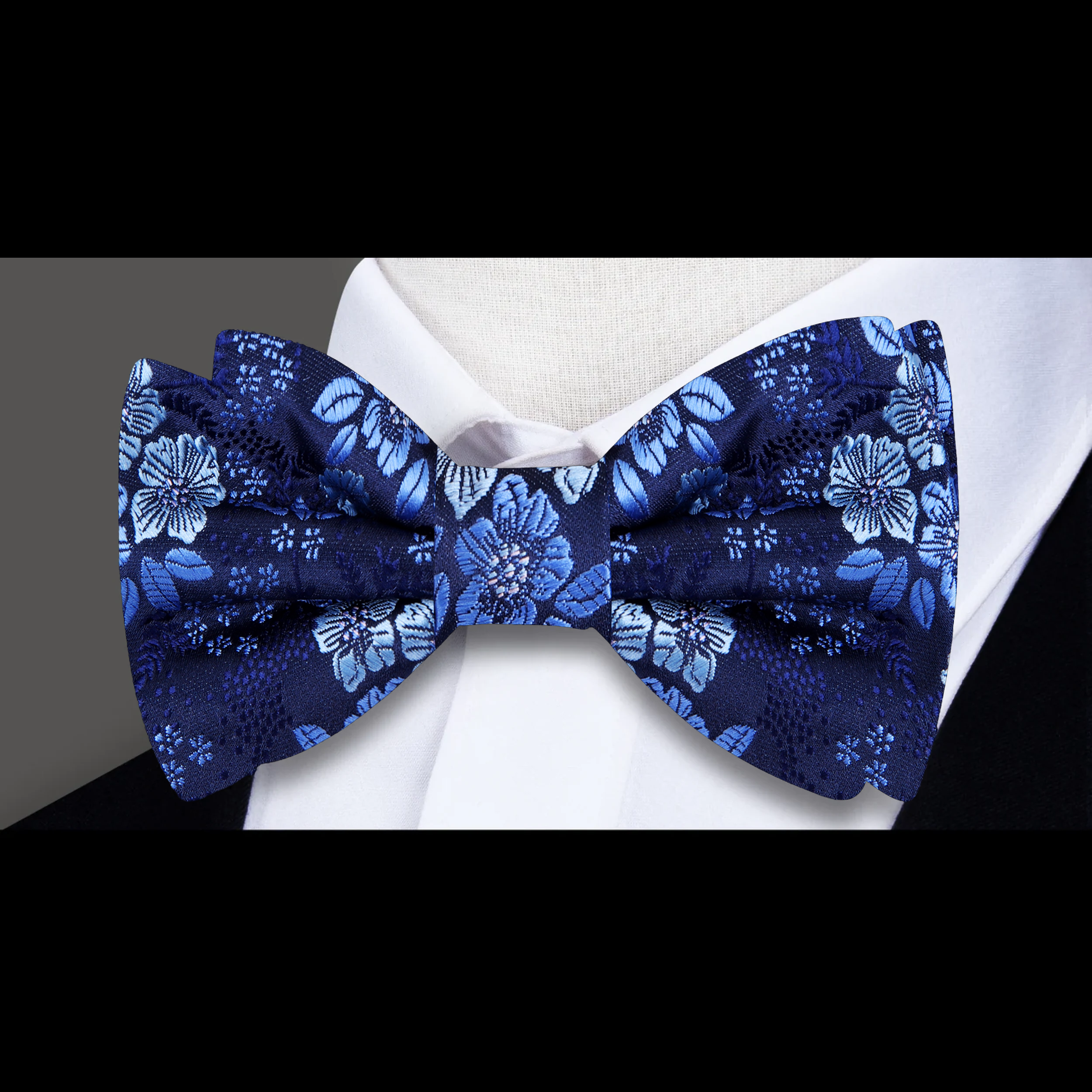 Elegant floral bow tie paired with a light grey suit, showcasing a fresh and versatile look.