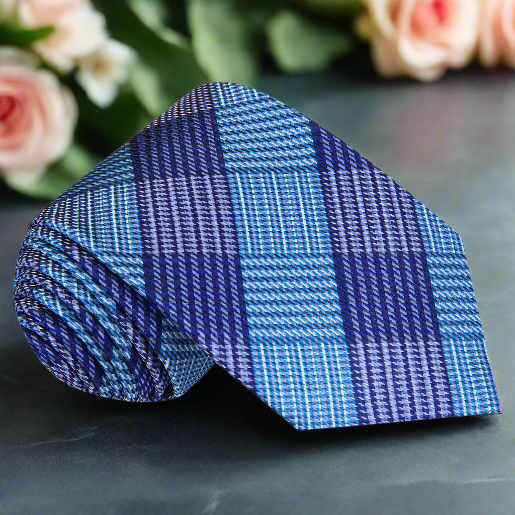 Elegant purple and blue silk plaid tie draped over a white shirt for formal occasions