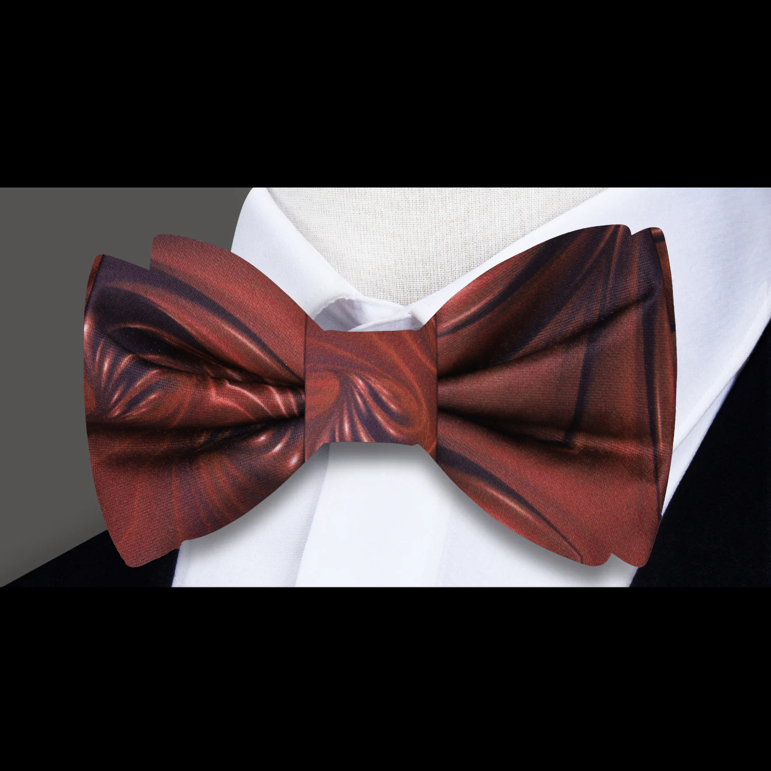 Elegant chocolate swirl silk bow tie displayed against a light blue dress shirt, highlighting its rich colors.