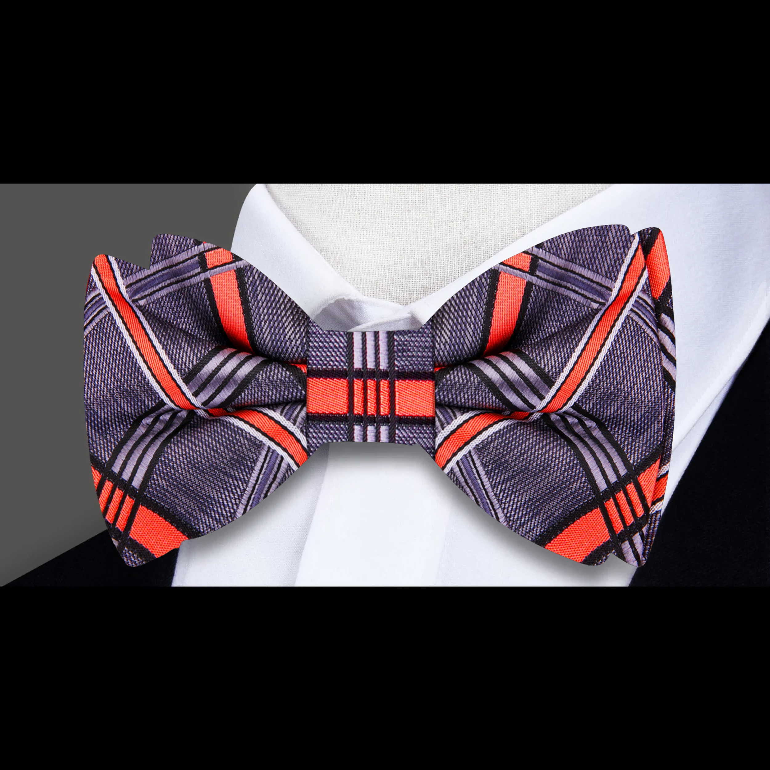 Close-up of the intricate plaid design of the silk bow tie against a light background.