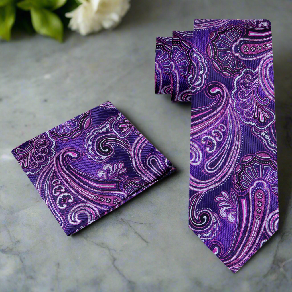 The purple paisley silk necktie styled with a charcoal suit, showcasing a polished look.