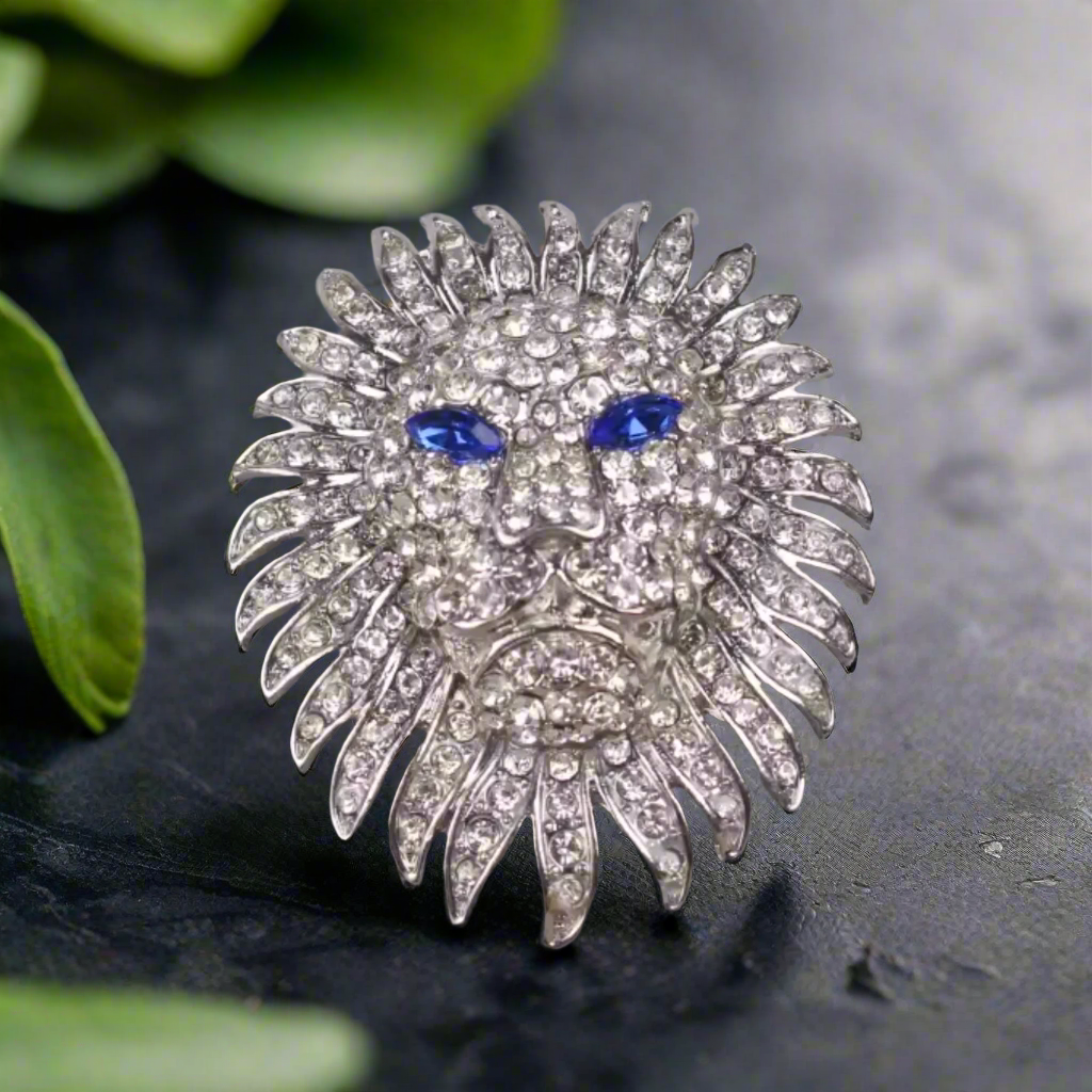Close-up view of the lion head gemstone lapel pin, showcasing intricate design and green gemstone eyes.